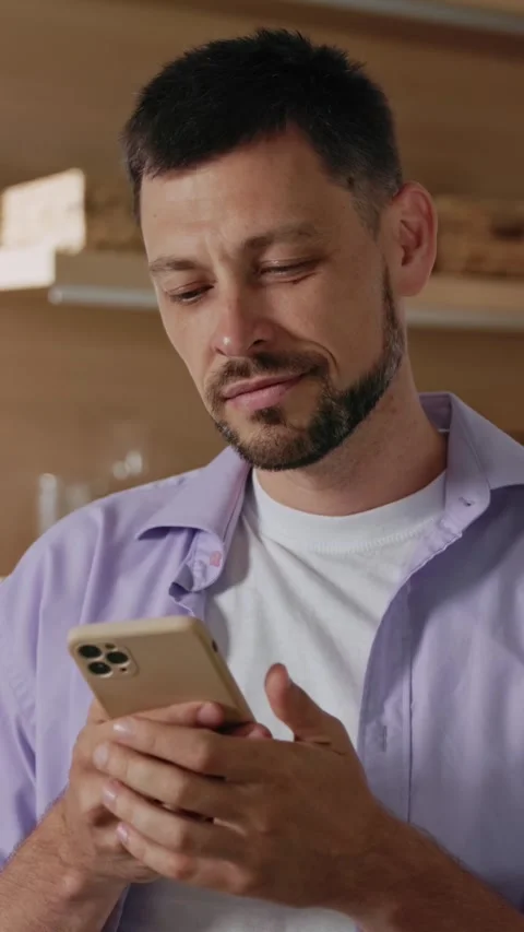A modern man is actively using a smartphone in a bustling urban environment and Stock Footage 314360198