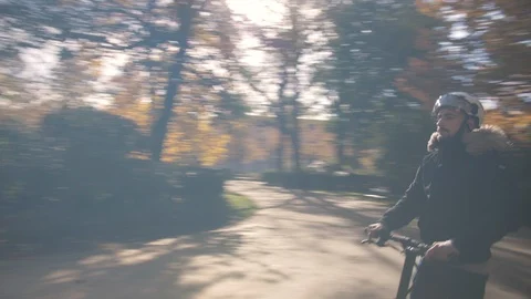 Modern Man with Helmet Using Electric Scooter in Sunny Park 1 Vidéo 98756945