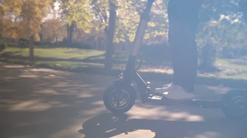 Modern Man with Helmet Using Electric Scooter in Sunny Park 3 Vidéo 98757125
