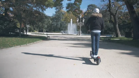 Modern Man with Helmet Using Electric Scooter in sunny Park with Fountain 1 Vidéo 98758729