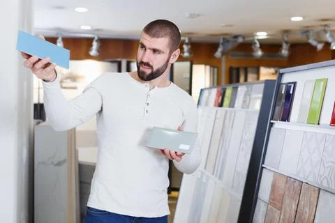 Modern man standing with sample of ceramic tile Stock Photos