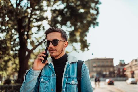 Modern man in sunglasses talking on the smartphone on the street Stock-Fotos
