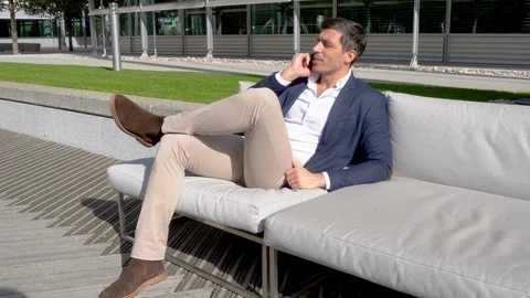 Modern man talking on phone doing business outside 4K Stock Footage 96060655