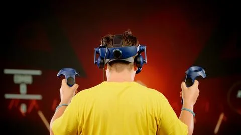 The modern man use tracking controllers in her hands, moves actively immersing Stock Photos