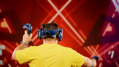 The modern man use tracking controllers in her hands, moves actively immersing Stock Photos