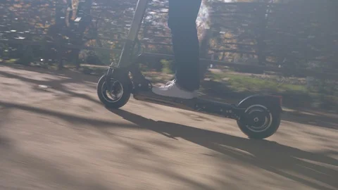 Modern Man Using Electric Scooter in Sunny Park Vidéo 98757102