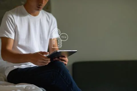 Modern Man Using Tablet in a Cozy Setting with Security Symbol Stock Photos