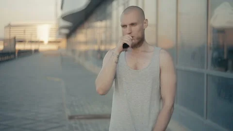 Modern man vaping outside in the warm summer evening 動画素材 85583015
