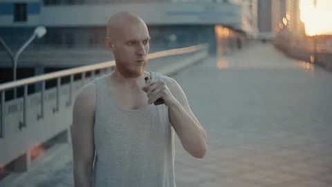 Modern man vaping outside in the warm summer evening 動画素材 85583135