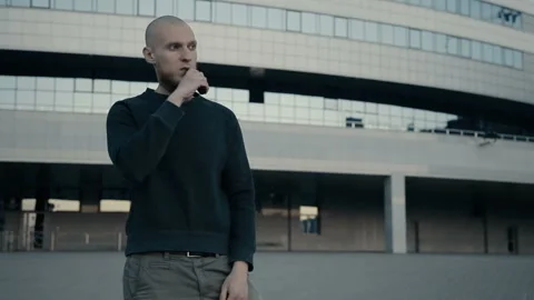 Modern man vaping outside in the warm summer evening Stockbeeldmateriaal 85611697