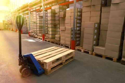 Modern manual forklift with wooden pallets in warehouse Stock Photos