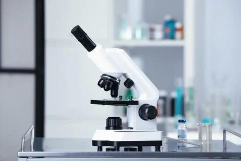 Modern medical microscope on gray table in laboratory Stock Photos
