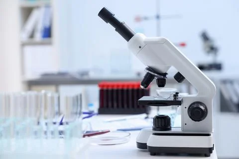 Modern medical microscope on white table in laboratory. Space for text Stock Photos