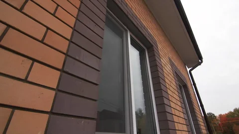 Modern metal-plastic window adorns brick wall of village Hall Видео 293305487