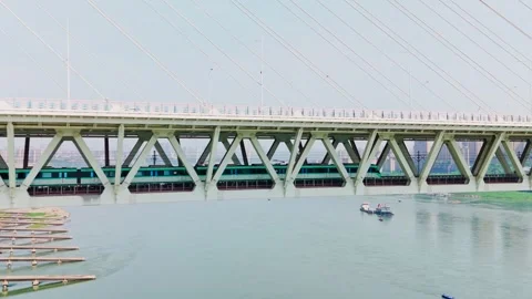 Modern metro train crossing the cable-stayed bridge over a river Stock Footage 330589352