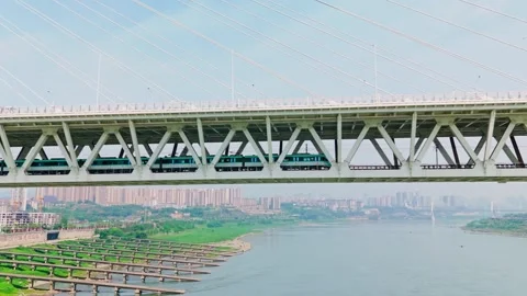 Modern metro train crossing the cable-stayed bridge over a river Stock Footage 330589386