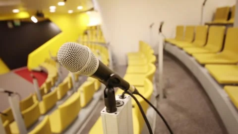 Modern microphone in empty auditorium with yellow seats Stock Footage 276362156