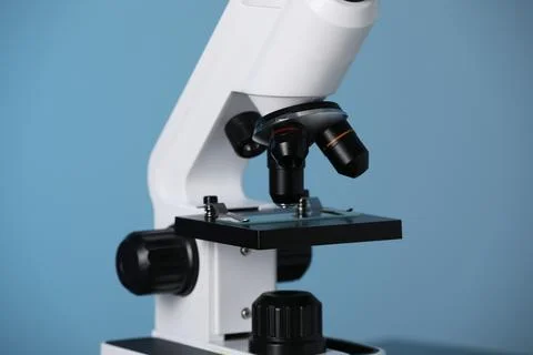 Modern microscope on blue background, closeup. Medical equipment Stock Photos