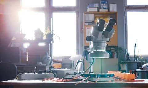 Modern microscope, connectors component and large green microcircuit in works Stock Photos