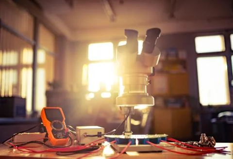 Modern microscope, connectors component and large green microcircuit in works Foto stock