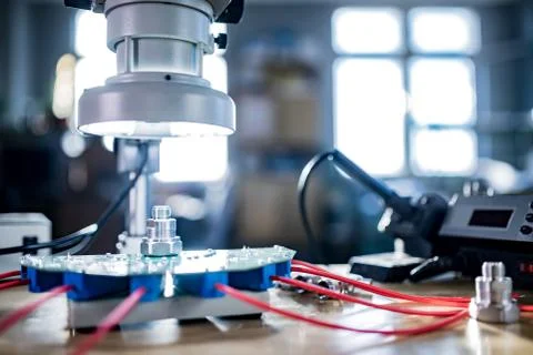 Modern microscope, connectors component and large green microcircuit in works Stock Photos