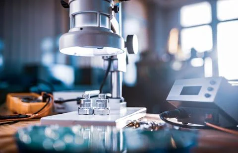 Modern microscope, connectors component and large green microcircuit in works Stock-Fotos
