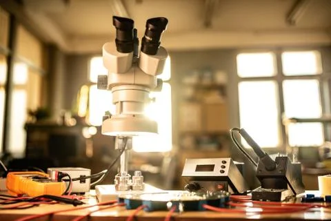 Modern microscope, connectors component and large green microcircuit in works Stock-Fotos