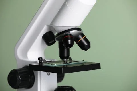Modern microscope on green background, closeup. Medical equipment Stock Photos