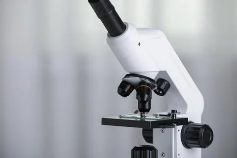 Modern microscope on light background, closeup. Space for text Stock Photos