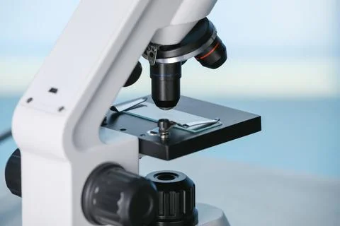 Modern microscope on light blue background, closeup. Medical equipment Stock Photos