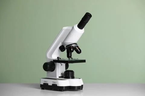 Modern microscope on table against green background 写真素材