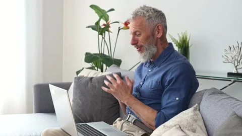 Modern middle-aged bearded man using laptop computer for virtual meeting Stock Footage 155432202