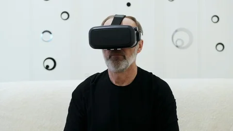 Modern middle-aged man with grey beard use VR headset, controls with hands Stock Footage 124618760