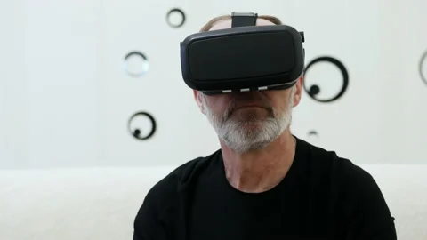Modern middle-aged man with grey beard use VR headset, looking around. Stock Footage 142434730