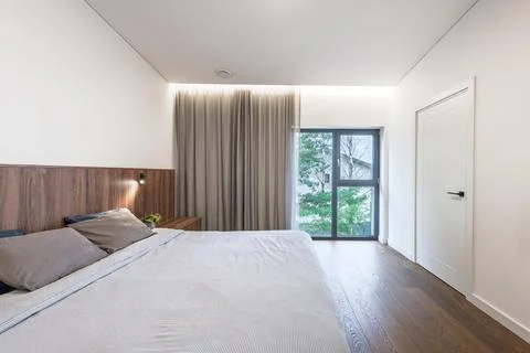 Modern Minimal Bedroom Interior With Large Window, Wooden Headboard and Neu.. Stock Photos