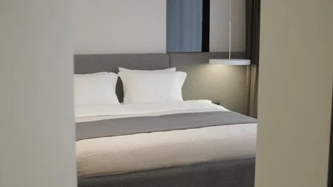 Modern minimalist bedroom with large bed and natural daylight. Stock Footage 330002849