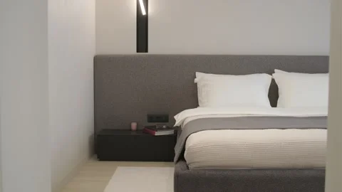 Modern minimalist bedroom with large bed and natural daylight. Stock Footage 330002917