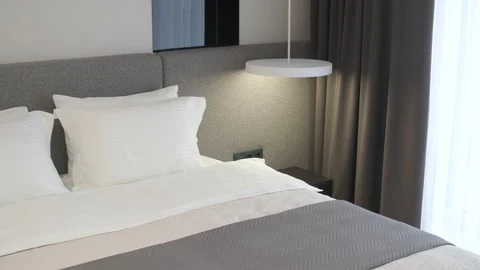Modern minimalist bedroom with large bed and natural daylight. Stock Footage 330002920