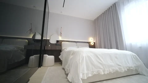 Modern minimalist bedroom with large bed and natural daylight. Stock Footage 330003846