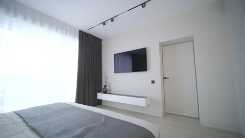 Modern minimalist bedroom with large bed and natural daylight. Stock Footage 330003933
