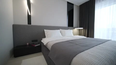 Modern minimalist bedroom with large bed and natural daylight. Stock Footage 330003975