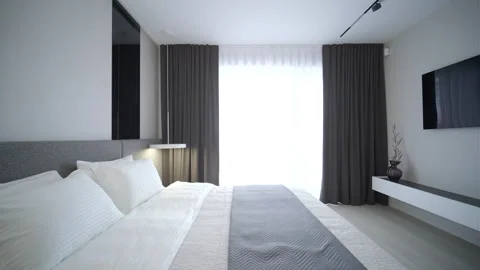 Modern minimalist bedroom with large bed and natural daylight. Stock Footage 330004012