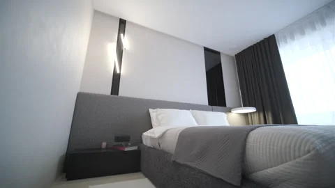 Modern minimalist bedroom with large bed and natural daylight. Stock Footage 330004338