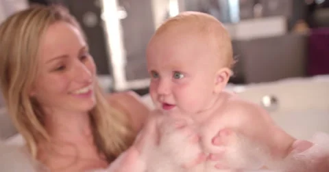 Modern Mom Takes Bubble Bath with Infant Daughter Stock Footage 61500630