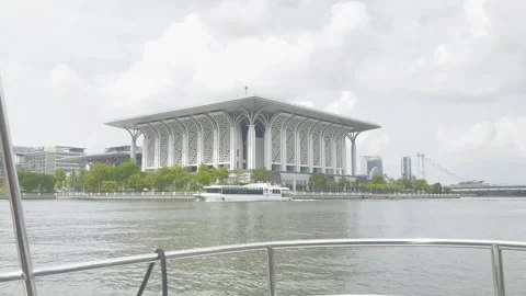 Modern mosque stands beside calm water under cloudy sky Stock Footage 340034319