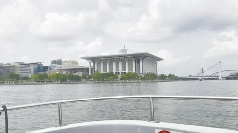 Modern mosque stands beside calm water under cloudy sky Stock Footage 340034322