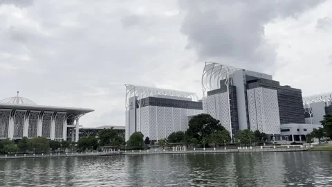 Modern mosque stands beside calm water under cloudy sky Stock Footage 340034402