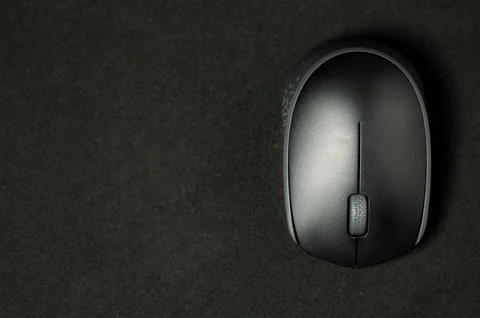 Modern mouse rests on dark surface. Stock Photos