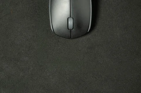 Modern mouse rests on dark surface. Stock Photos