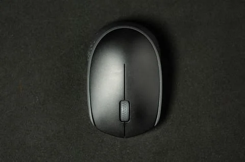 Modern mouse rests on dark surface. Stock Photos